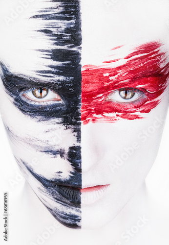 Fototapeta na wymiar Woman with white makeup and red and black stripes paint