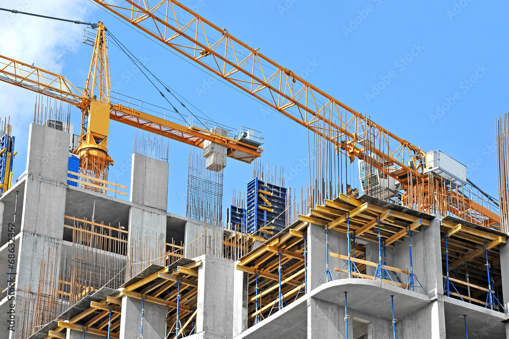 Crane and building construction site against blue sky - obrazy, fototapety, plakaty 