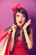 © Masson - Beautiful brunette girl with shopping bags on violet background.