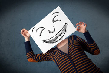 Wall Mural - Woman with drawed smiley face on a paper in front of her head