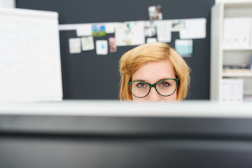 Poster - frau mit brille schaut über monitor