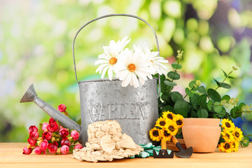 Canvas Print - Gardening tools and flowers on wooden table, outdoors