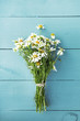 summer bouquet of chamomile on the old blue wooden background