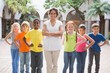 © WavebreakmediaMicro - Pretty teacher standing with pupils in courtyard