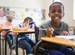 © WavebreakmediaMicro - Disabled pupil smiling at camera in classroom
