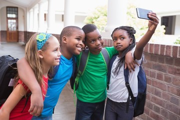 Wall Mural - Cute pupils taking a selfie in the corridor