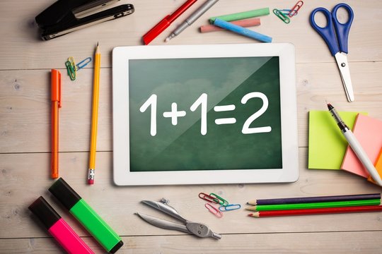 Composite image of digital tablet on students desk