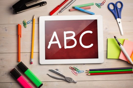 Composite image of digital tablet on students desk