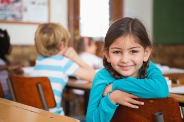 Smiling pupil sitting at her desk