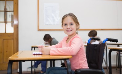 Wall Mural - Disabled pupil smiling at camera in classroom