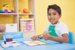 © WavebreakMediaMicro - Cute little boy painting at table in classroom