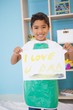 © WavebreakMediaMicro - Cute little boy showing his painting in classroom