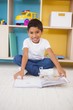 © WavebreakMediaMicro - Cute little boy sitting on floor reading in classroom