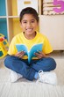 © WavebreakMediaMicro - Cute little boy sitting on floor reading in classroom
