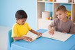 © WavebreakMediaMicro - Cute little boys reading at desk in classroom