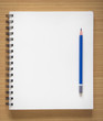 © aopsan - blank spiral notebook and pencil on wood background