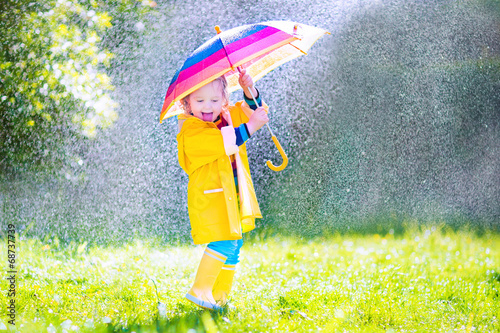 Fotografie, Obraz Funny little toddler with umbrella playing in the rain