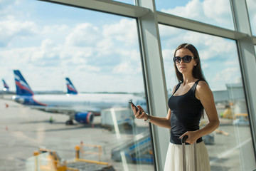 Young beautiful woman talking on the phone while waiting for