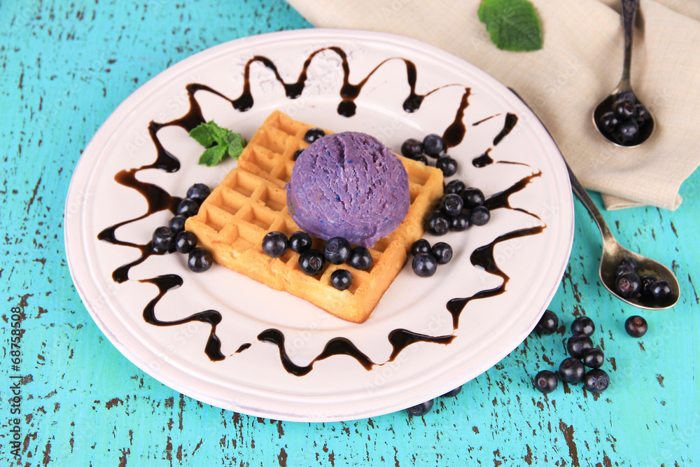 Tasty belgian waffles with ice cream on wooden table