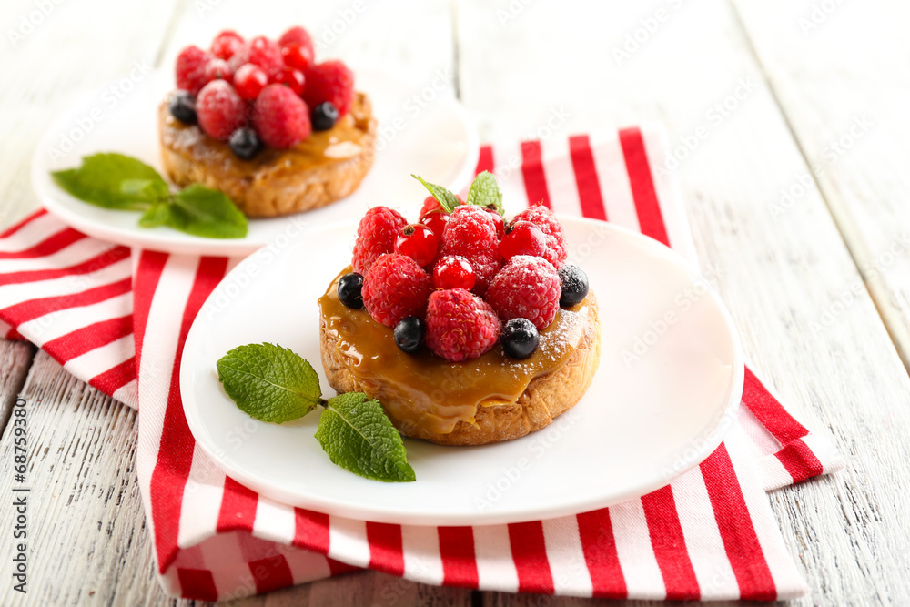 Sweet cakes with berries on table close-up