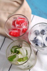 Wall Mural - Ice cubes with mint leaves, raspberry and blueberry in glasses,