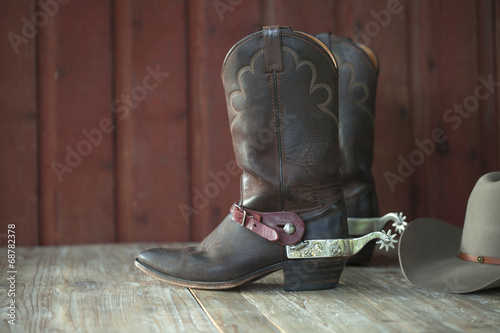 Fotografia, Obraz Cowboy boots, spurs and hat on old wood background