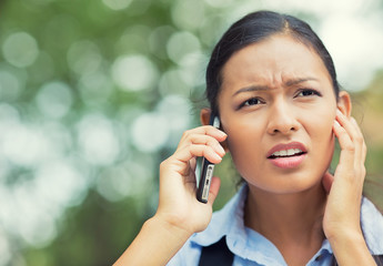 unhappy, stressed woman talking on mobile phone outside