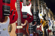 Many electric guitars hanging on wall in the shop.