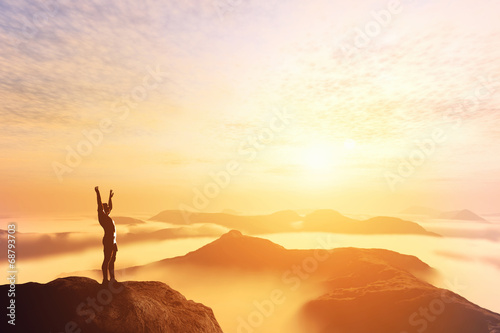 Fotografía Happy man with hands up on the top of the world above clouds
