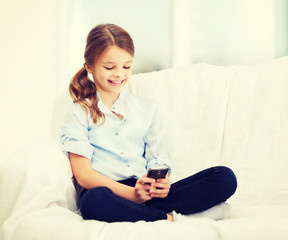 Wall Mural - smiling girl with smartphone at home