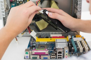 Young technician working on broken computer