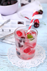 Wall Mural - Cold cocktail with forest berries, frozen in ice cubes