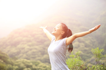 Wall Mural - cheering hiking woman open arms mountain peak