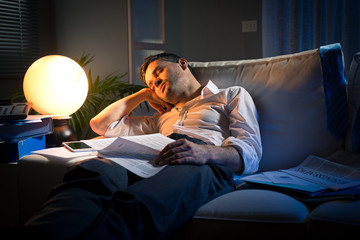 Overworked businessman on sofa