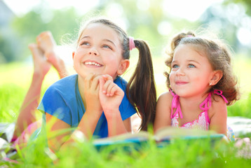 Two little girls are reading book