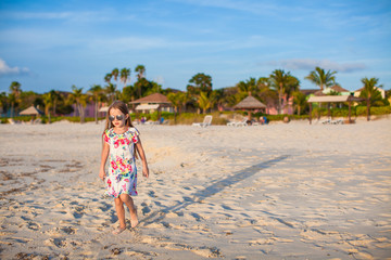 Poster - Adorable little girl walking at white tropical beach