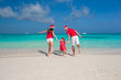 © travnikovstudio - Happy family in Santa Hats on beach during caribbean vacation