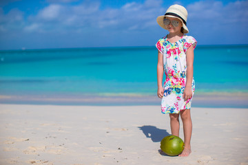 Wall Mural - Adorable little girl with coconut at white beach have fun