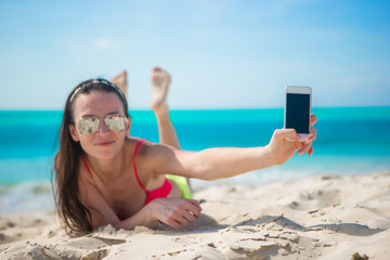 Sticker - Young woman with her cell phone on white beach