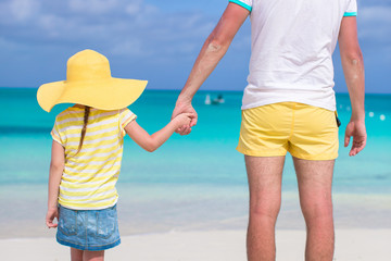 Poster - Close up of little girl holding her father hand on the beach