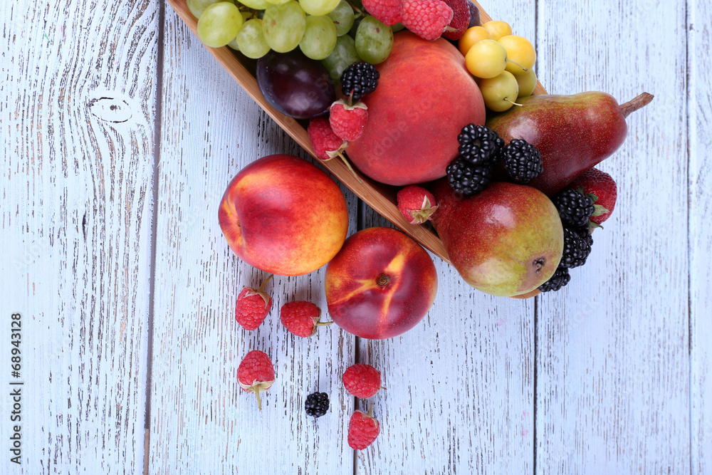 Different berries and fruits on wooden table close-up