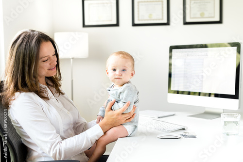 Obraz na plátně Businesswoman in Office with Baby