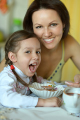 Wall Mural - Little girl with mother eats