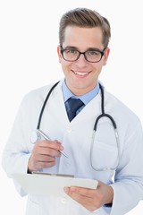 Poster - Smiling young doctor writing on clipboard