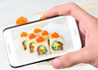 Hands taking photo sushi   with smartphone