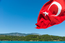 Turkish Flag On A Background Of Sky And Water.