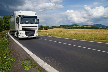 White truck on the road in a rural landscape