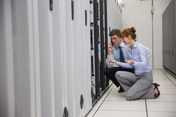 Poster - Team of technicians kneeling and looking at servers