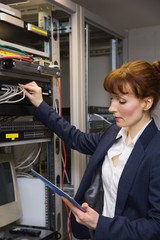 Wall Mural - Pretty technician using tablet pc while fixing server