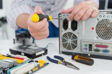 Young technician working on broken computer